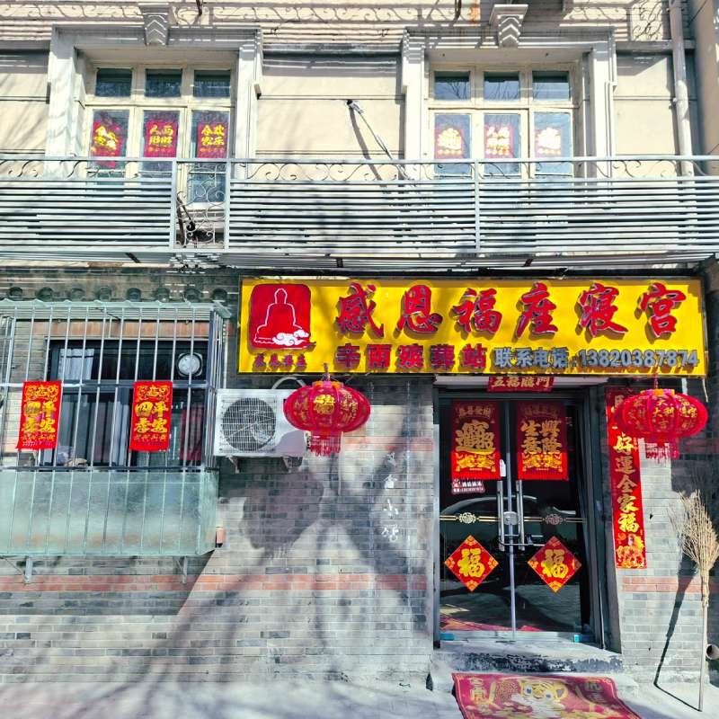Storefront with Chinese decorations: red lanterns, red couplets, and a bright yellow signboard outside the shop.